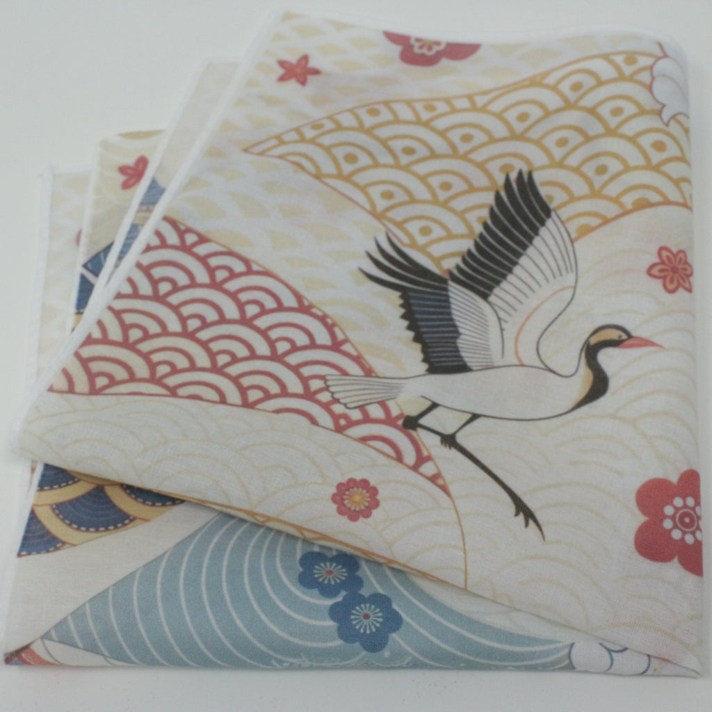 Cotton cloth pocket square handkerchiefs on a plain white background. flying crane with black and white wings, red and pink waves, and small floral motifs on an off-white base.