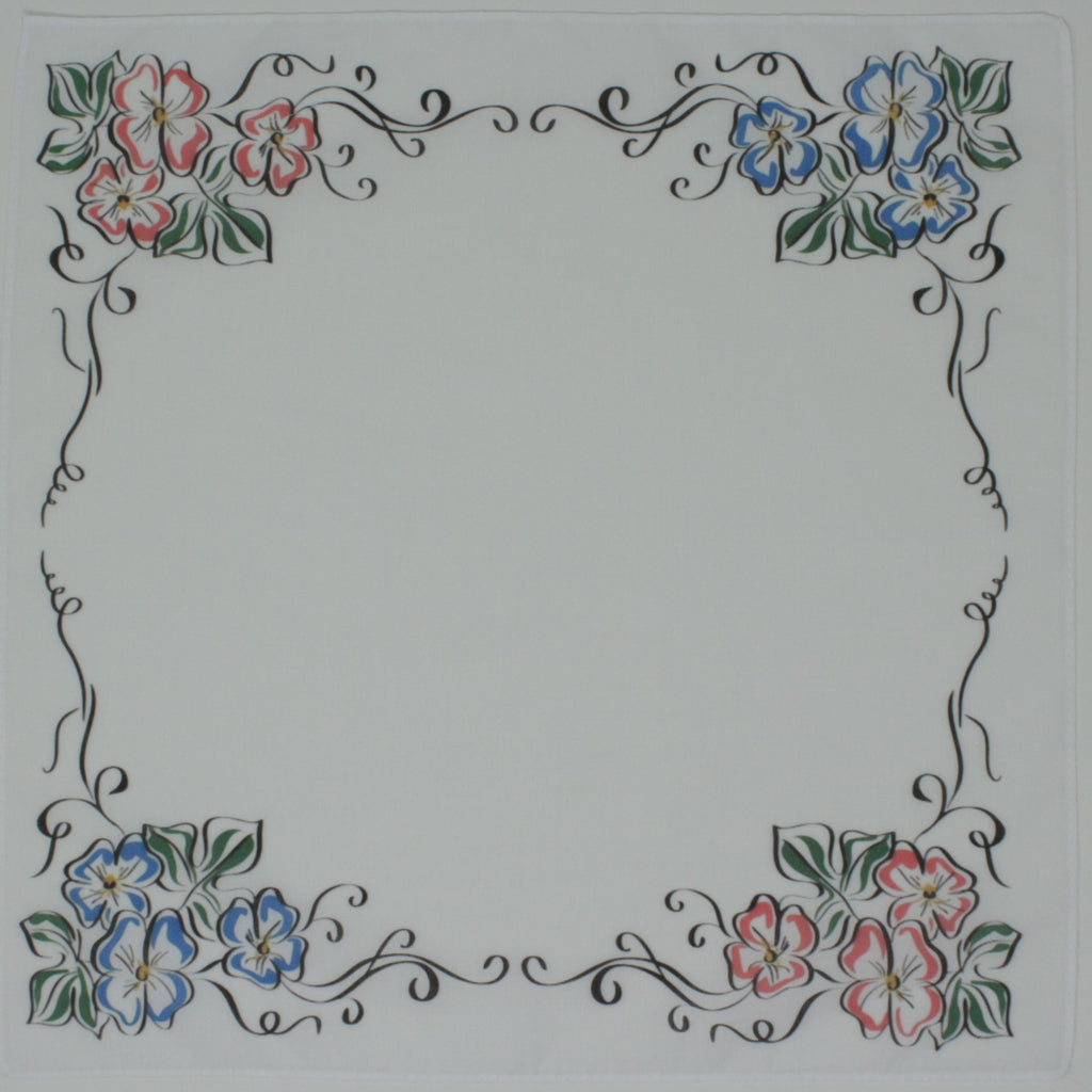 A square white cotton handkierchief, decorative floral border design in the corners, with pink and blue flowers, green leaves, and black scrollwork.