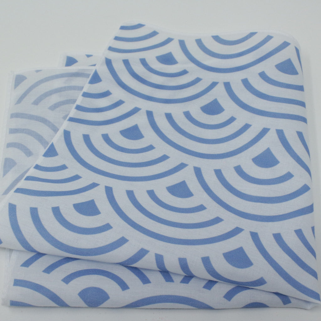 A folded cotton handkerchief pocket square, featuring a repeating blue scallop or wave-like geometric pattern. Japanese